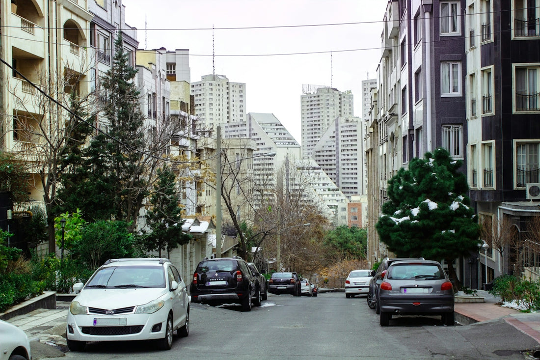 A street filled with lots of parked cars next to tall buildings
