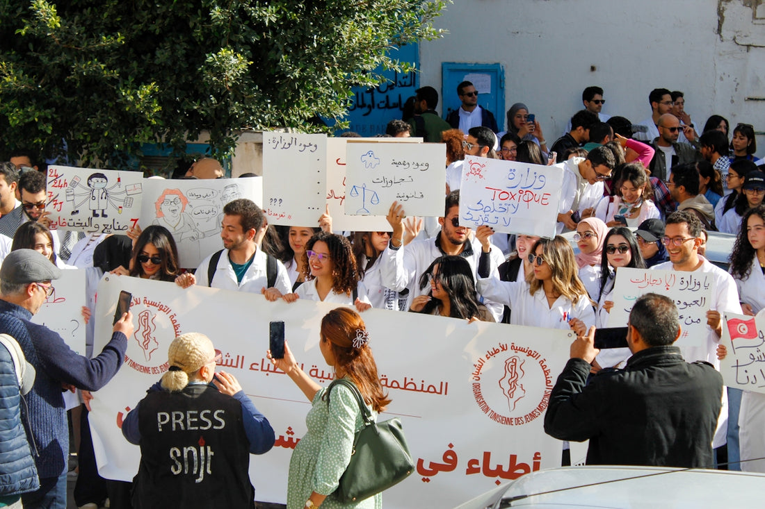 Protesters hold signs and banners at a rally.