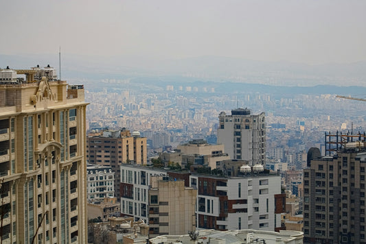 A sprawling cityscape with numerous buildings under a hazy sky.