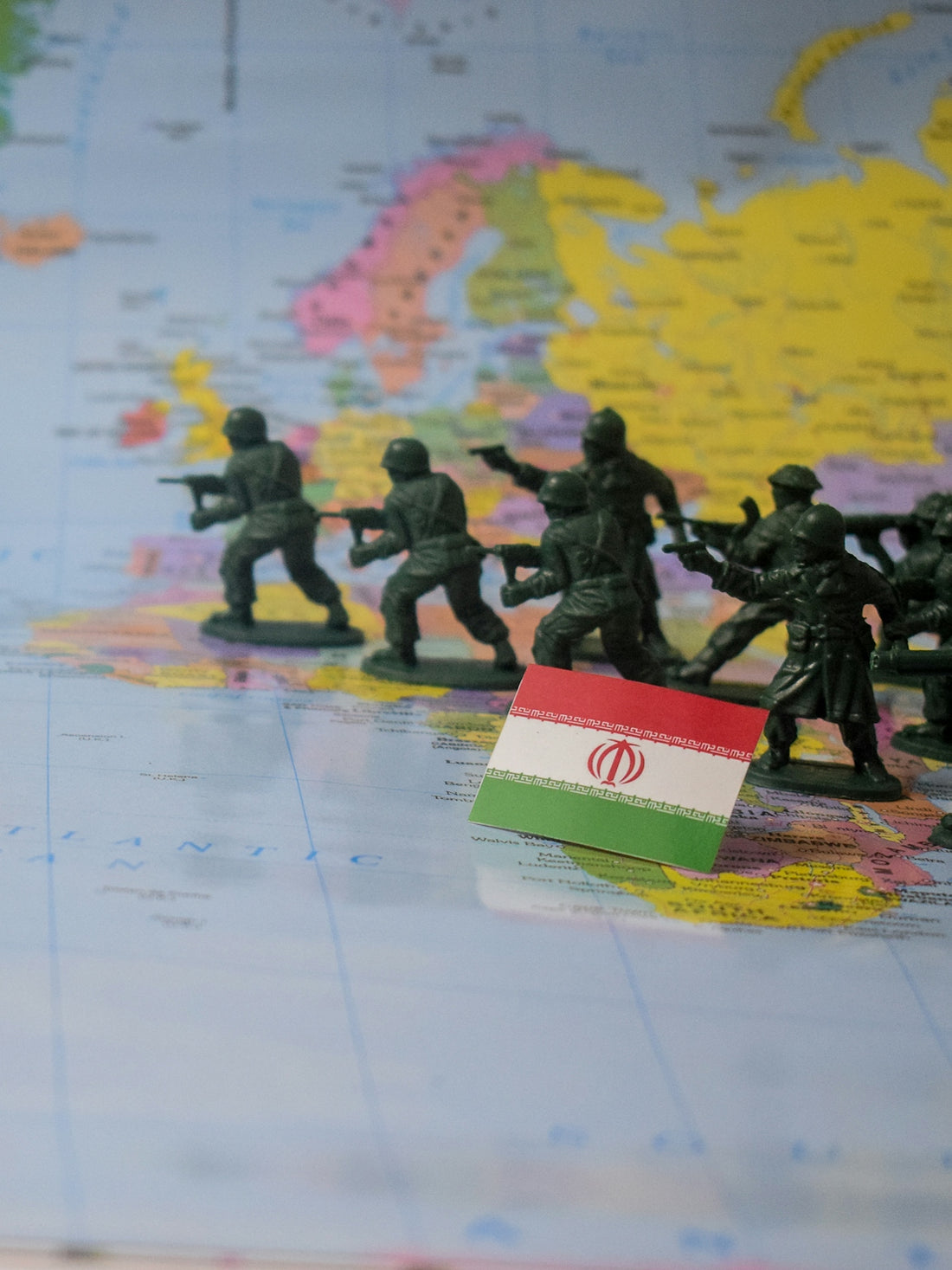 Toy soldiers advance on iran flag on map