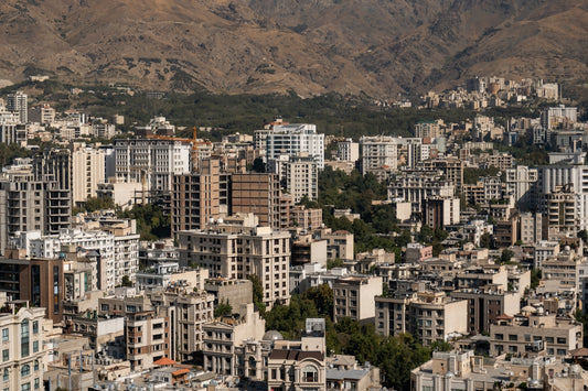 Cityscape with many buildings and distant mountains.