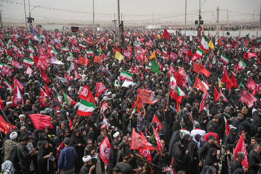 A massive crowd of people waving red and green flags